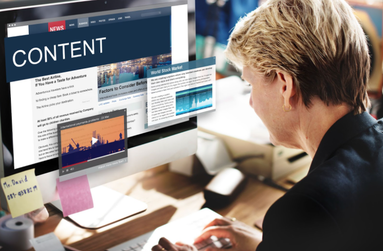 Creative workspace showing AI-powered content creation tools on multiple screens with marketing materials